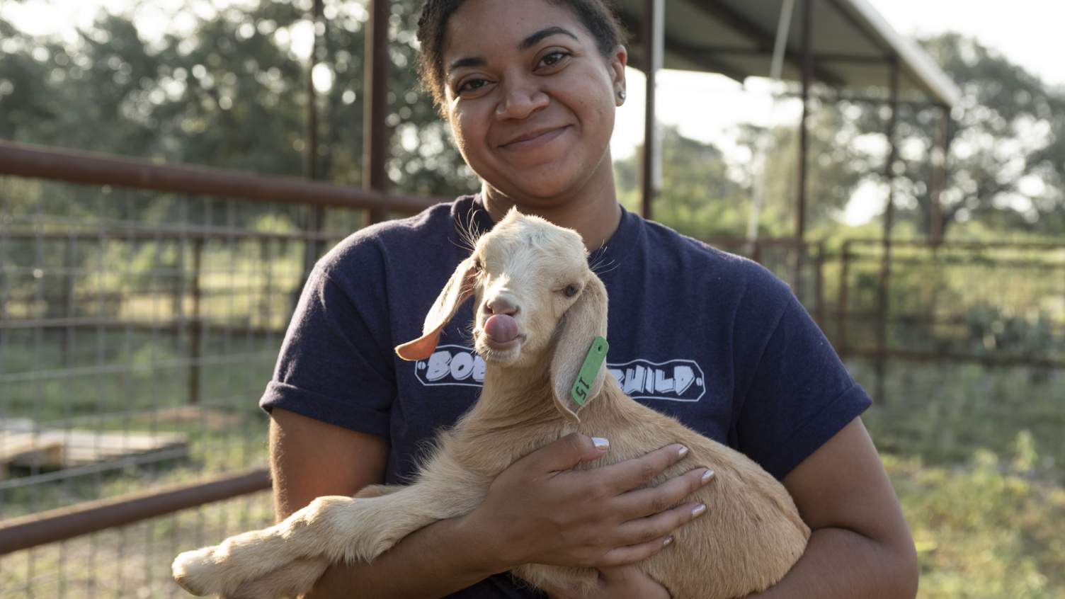 student holding baby goat