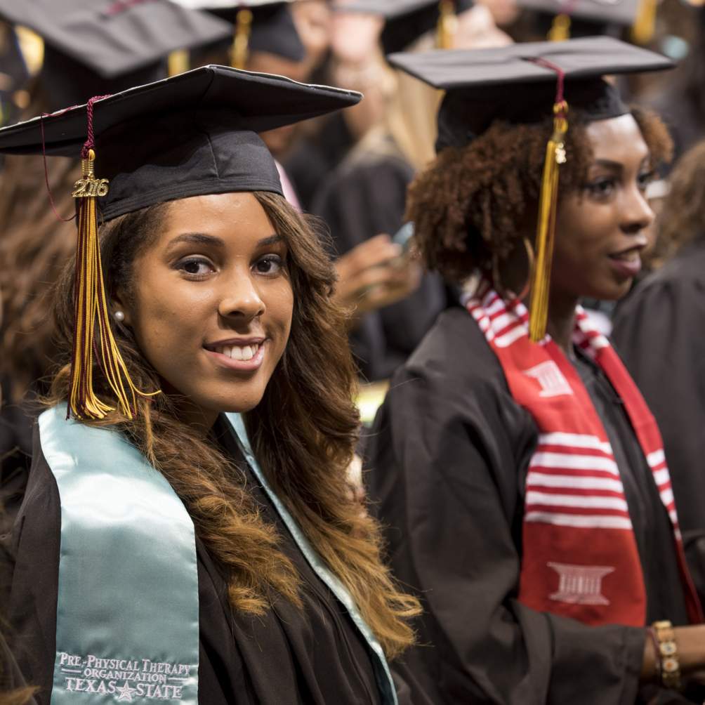 Baccalaureate candidates share their joy with the camera at a Summer 2016 commencement ceremony, some wearing stoles to celebrate their undergraduate accomplishments.
