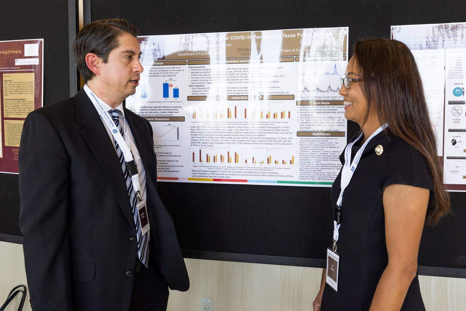 Two people standing in front of a research poster
