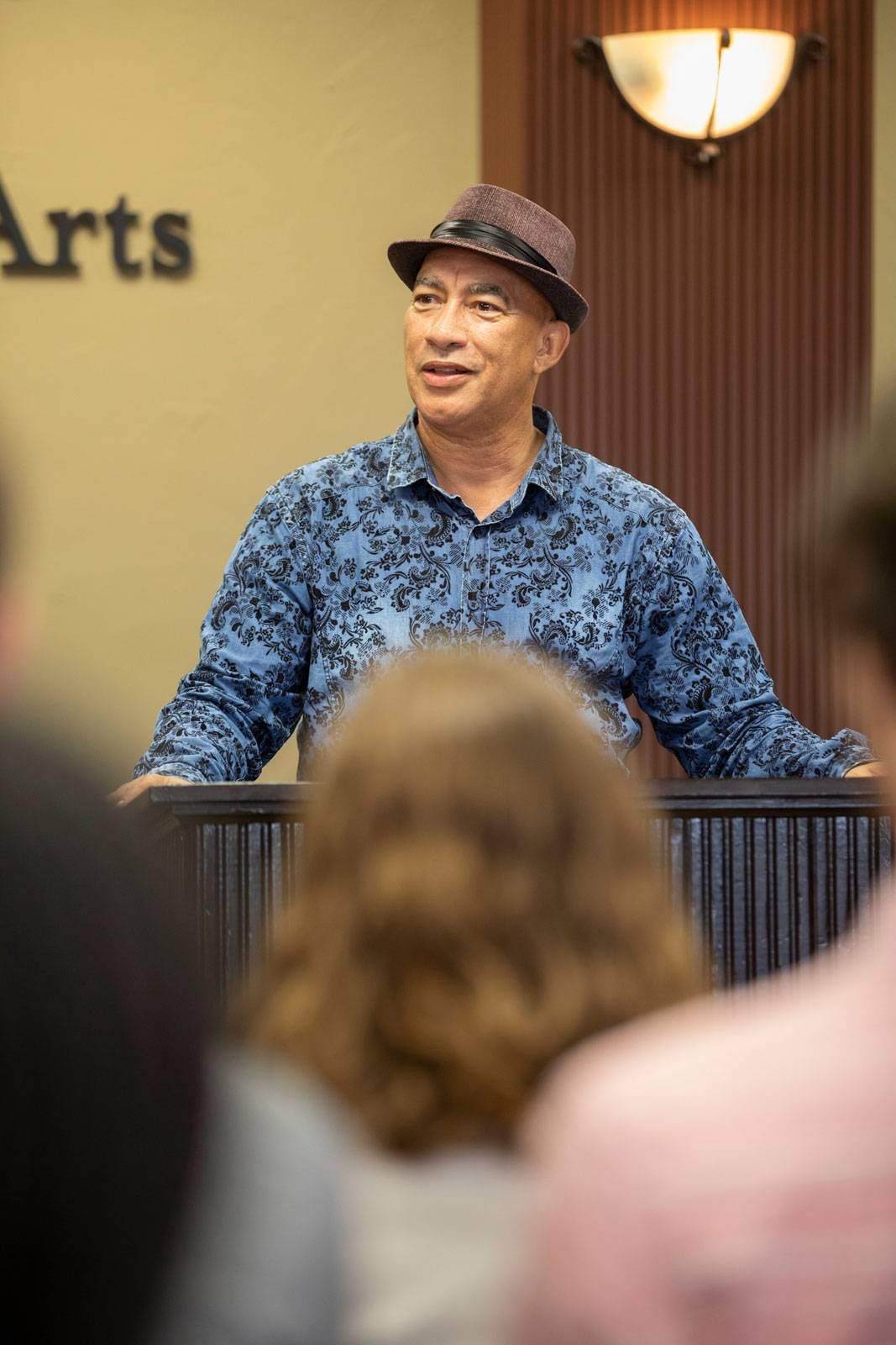 Cyrus Cassells stands at a podium at a poetry reading