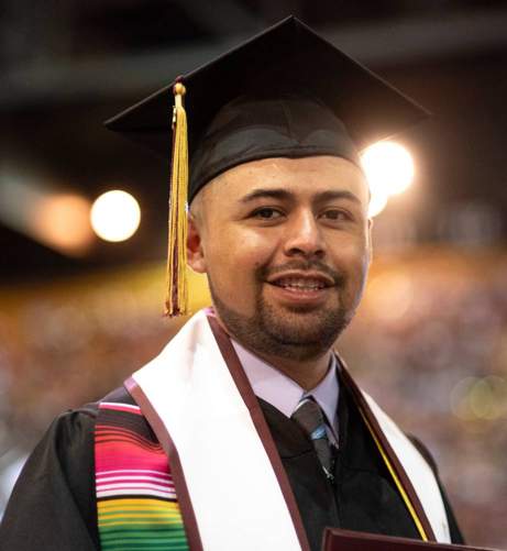 hispanic man in graduation cap and gown