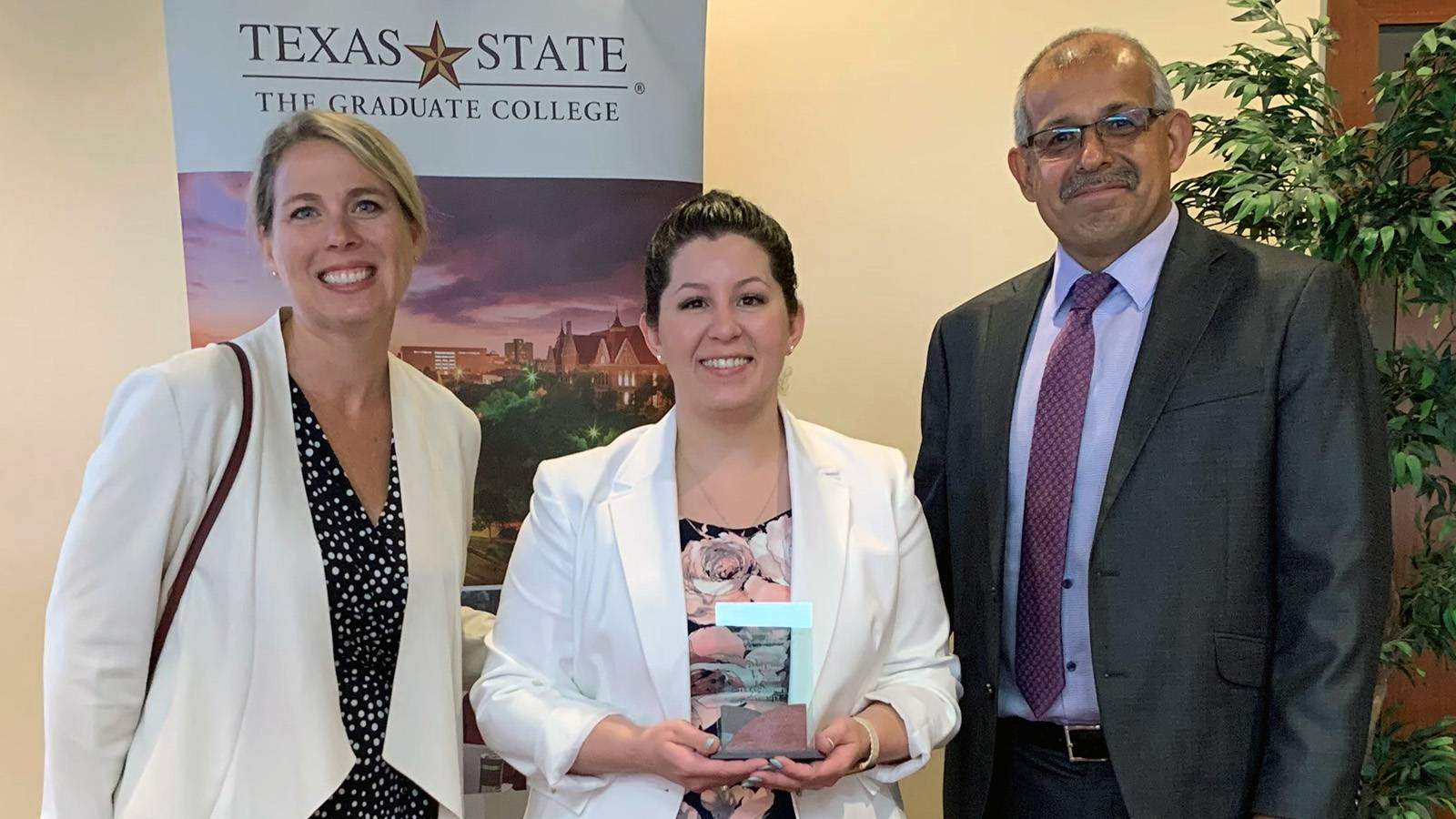 Dr. Kasey Martin, Liesel Bass holding award, and Dr. Diego Vacaflores