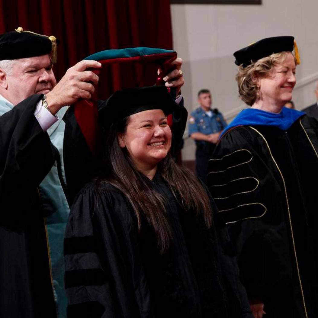 Doctoral candidate gets hooded by faculty 