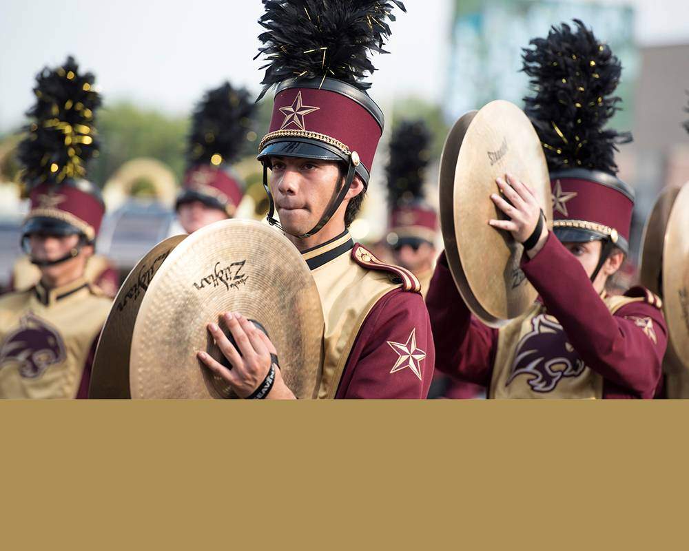 Gold cymbals in marching band with stripe of gold color