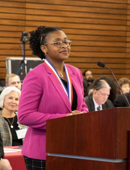 precious orusa speaking behind podium