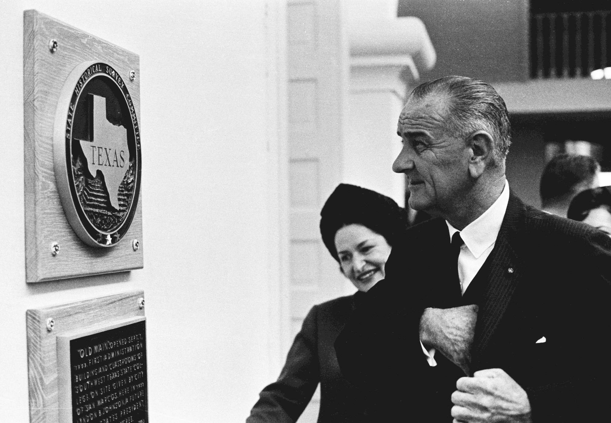 President Lyndon B Johnson looking at plaque of Texas