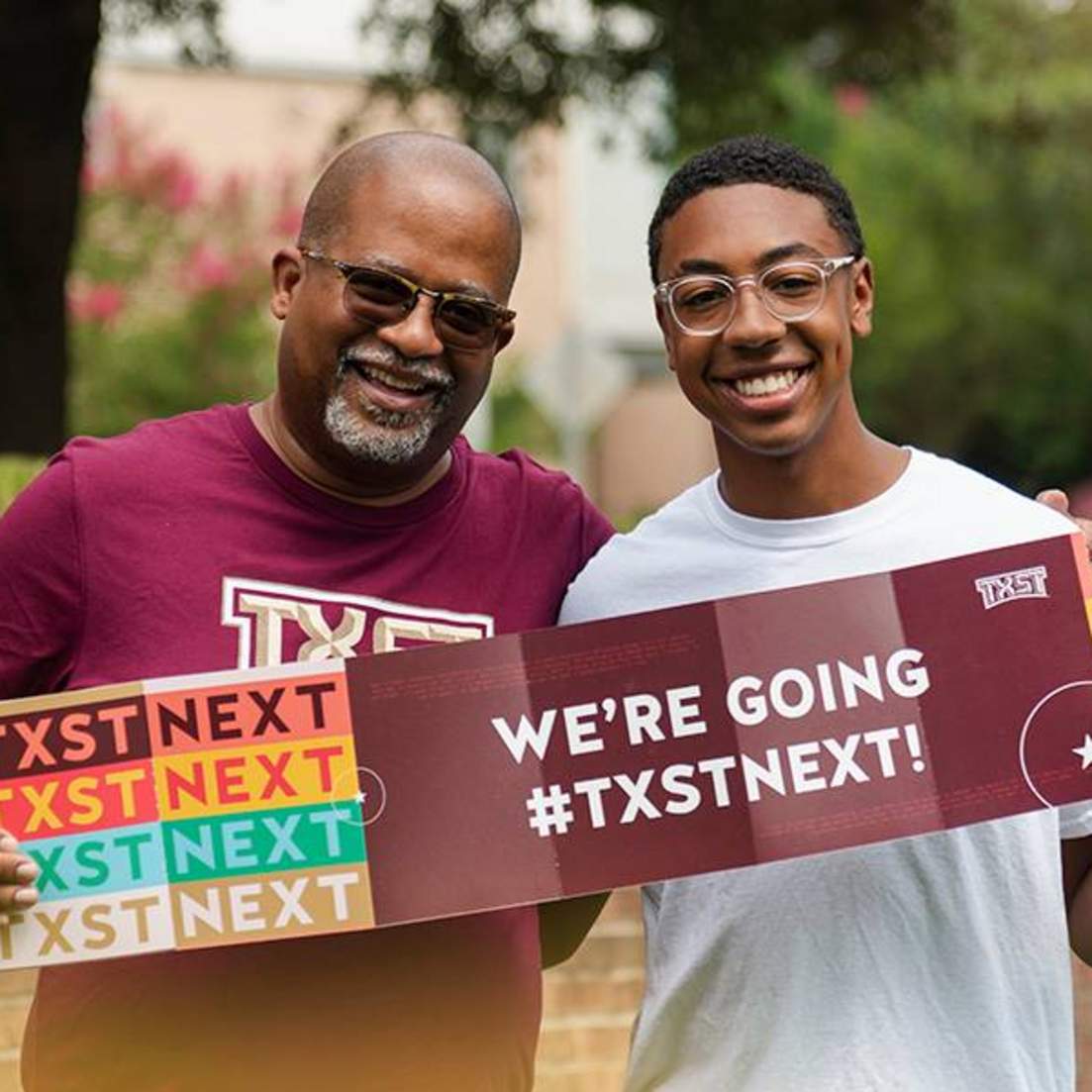 two men holding up sign reading "we're going #txstnext"