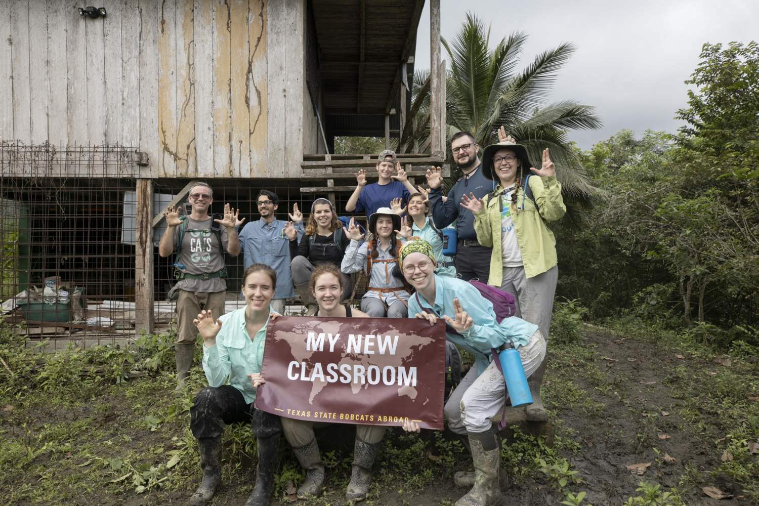 group photo of students and faculty in front of an old ranch house in Ecuador