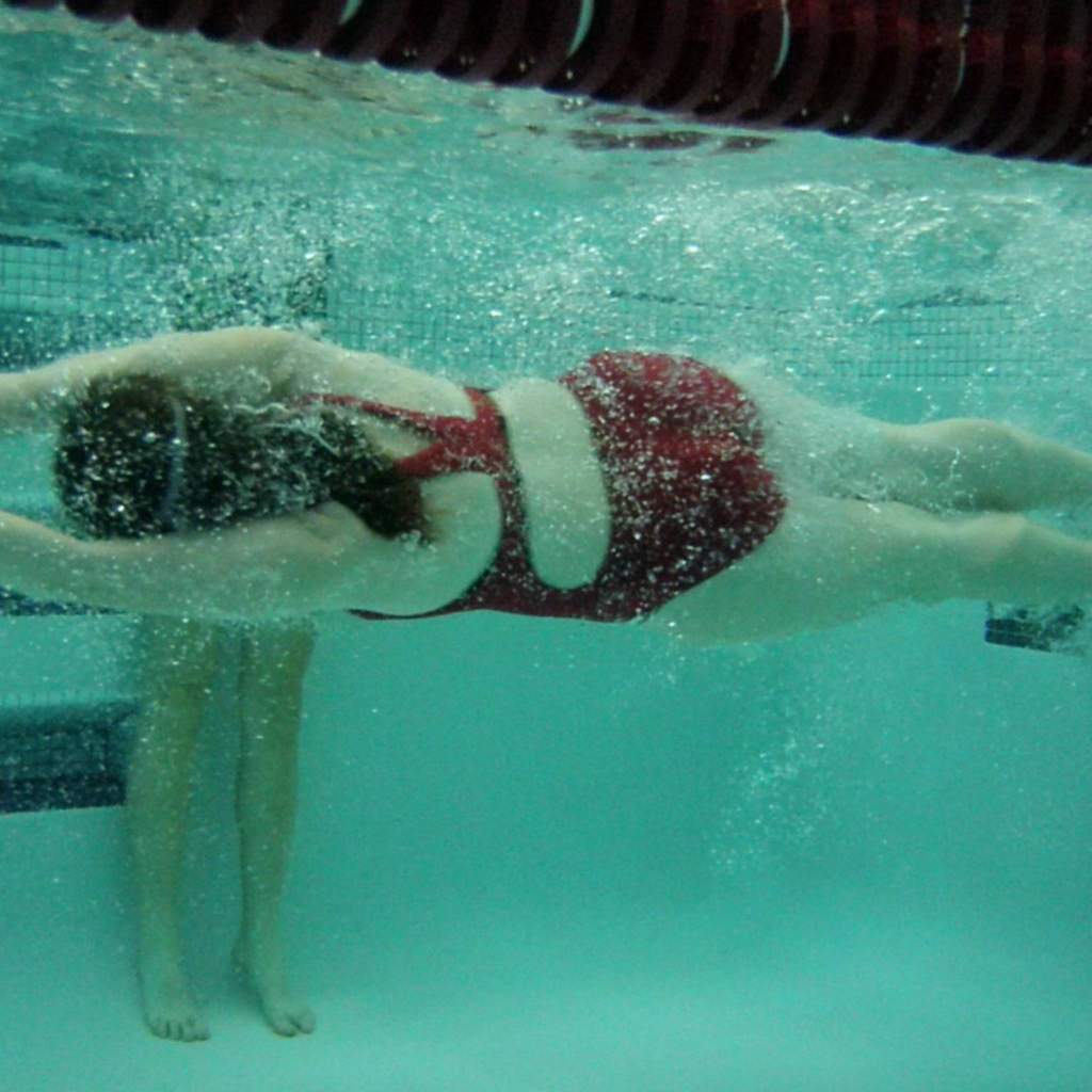 swimmer pushing off wall under water