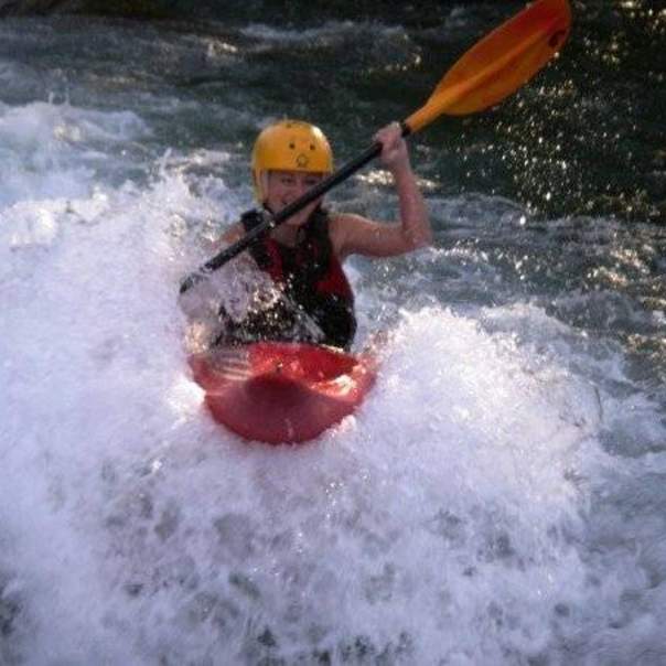 Student in kayak going through rapids