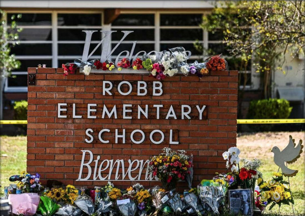 brick sign outside of robb elementary school with memorial
