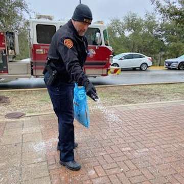 police officer salting sidewalk