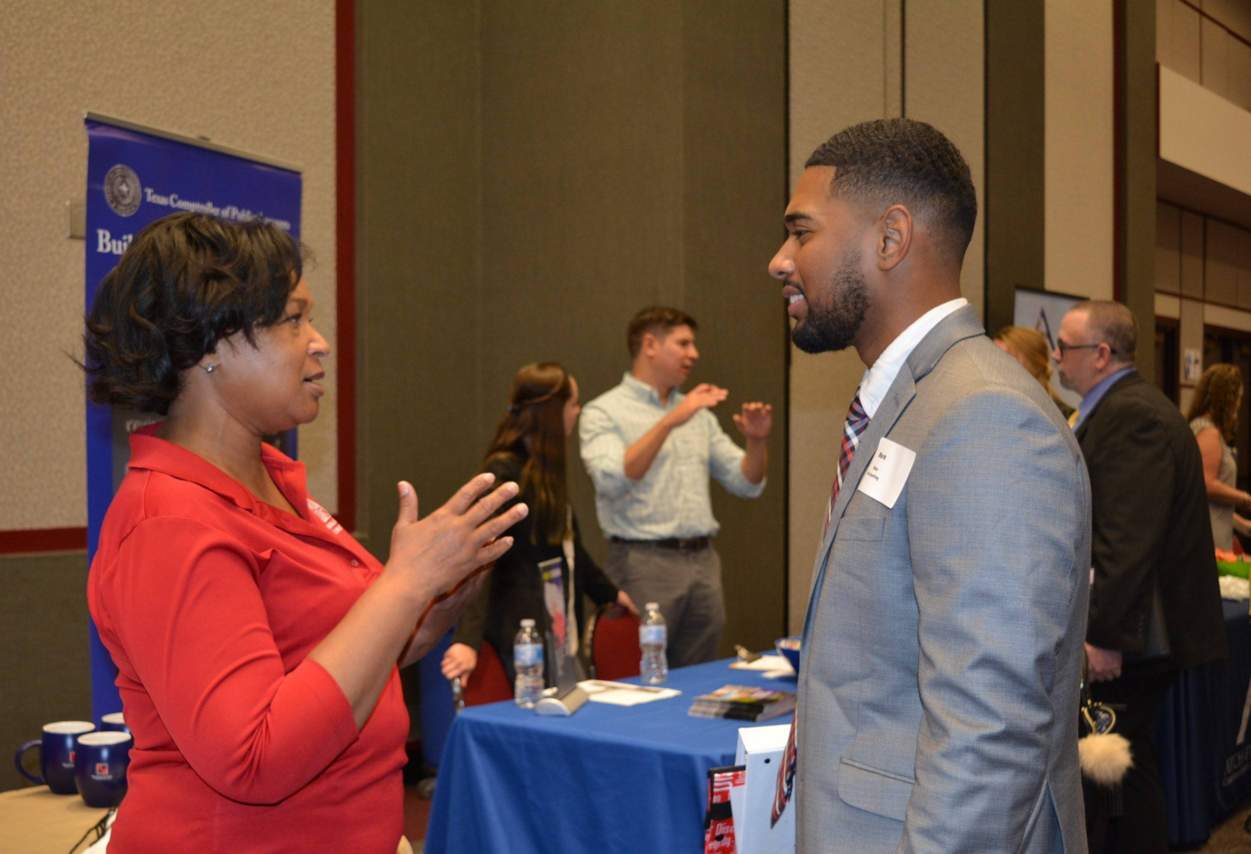 student speaking with an employer at a job fair