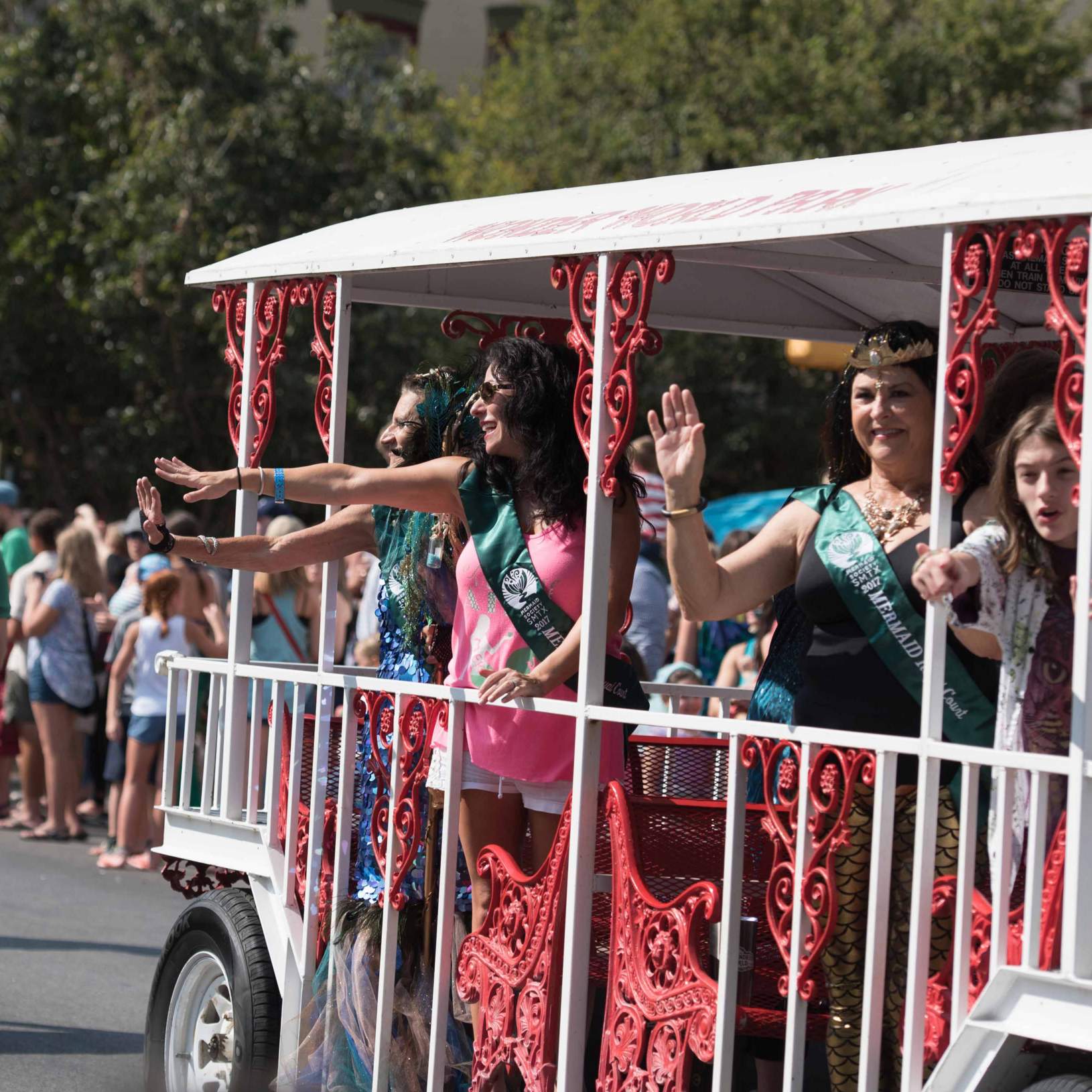 a trolley full of mermaids passes during the mermaid parade
