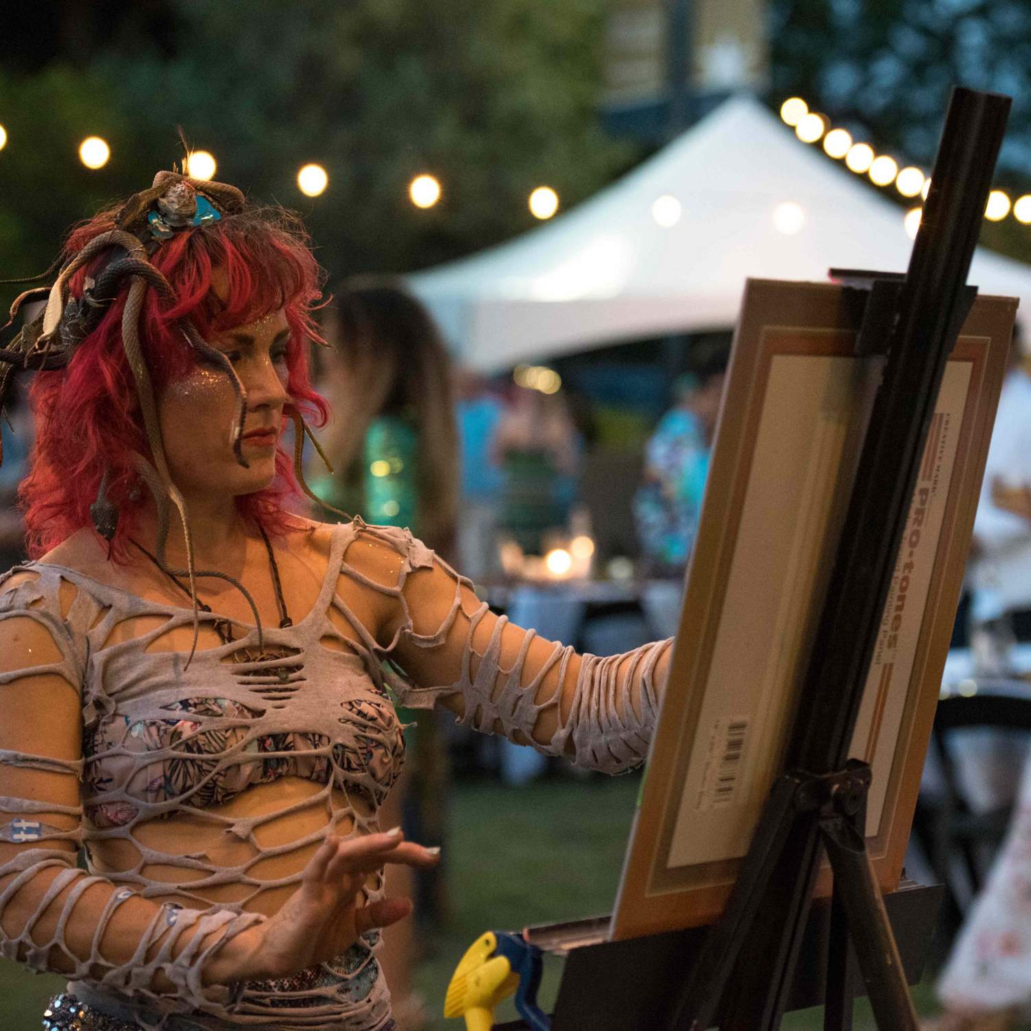 a woman dressed as a mermaid paints at the mermaid society ball