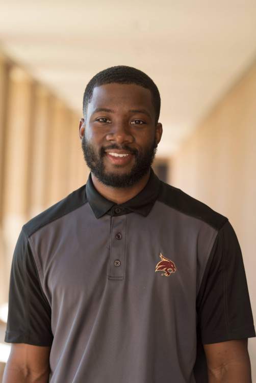 Ervin Brown smiling in a black polo shirt.