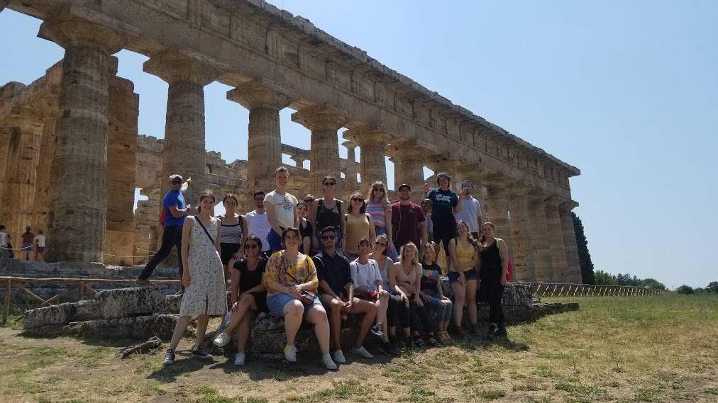 Group of people posing in front of Roman ruins