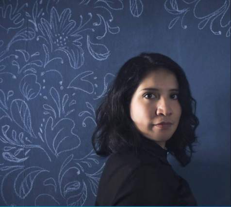 headshot of Erika Meza with a dark blue background