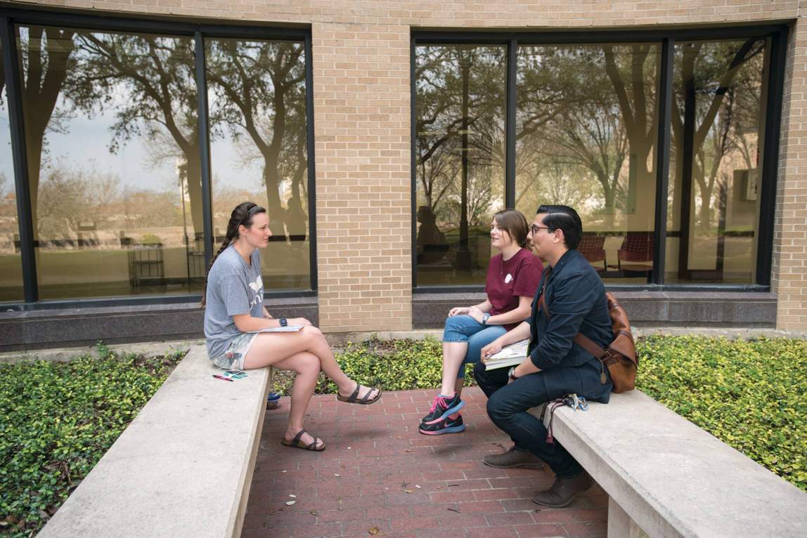 students sitting outside in benches