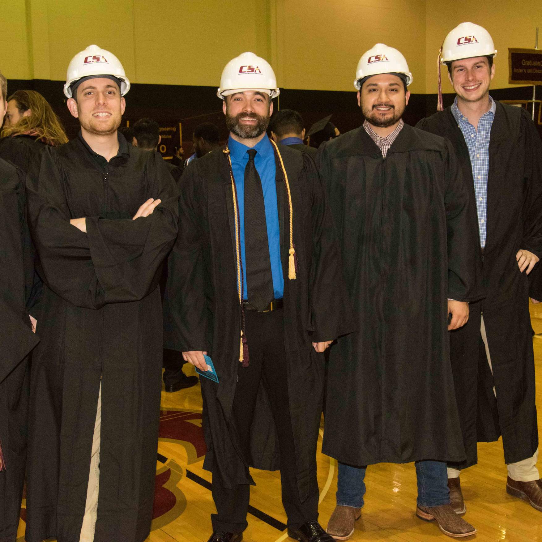 Graduates wearing hard hats during the College of Science and Engineering ceremony.
