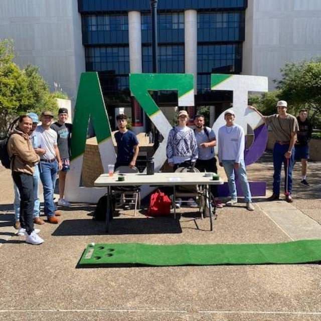 fraternity members at booth on campus