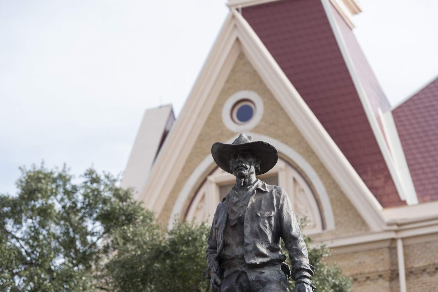 Photo of Vaquero Statue in front of Old Main Building
