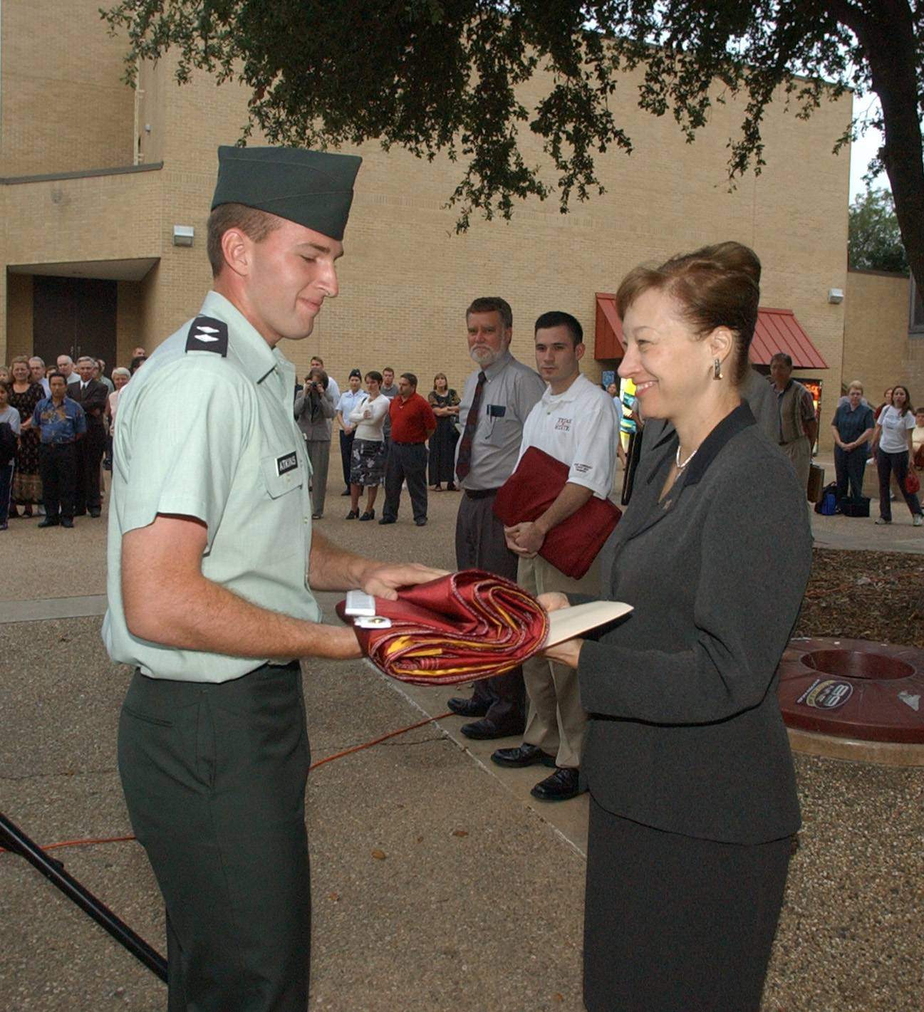 dr trauth handing flag to someone in military uniform