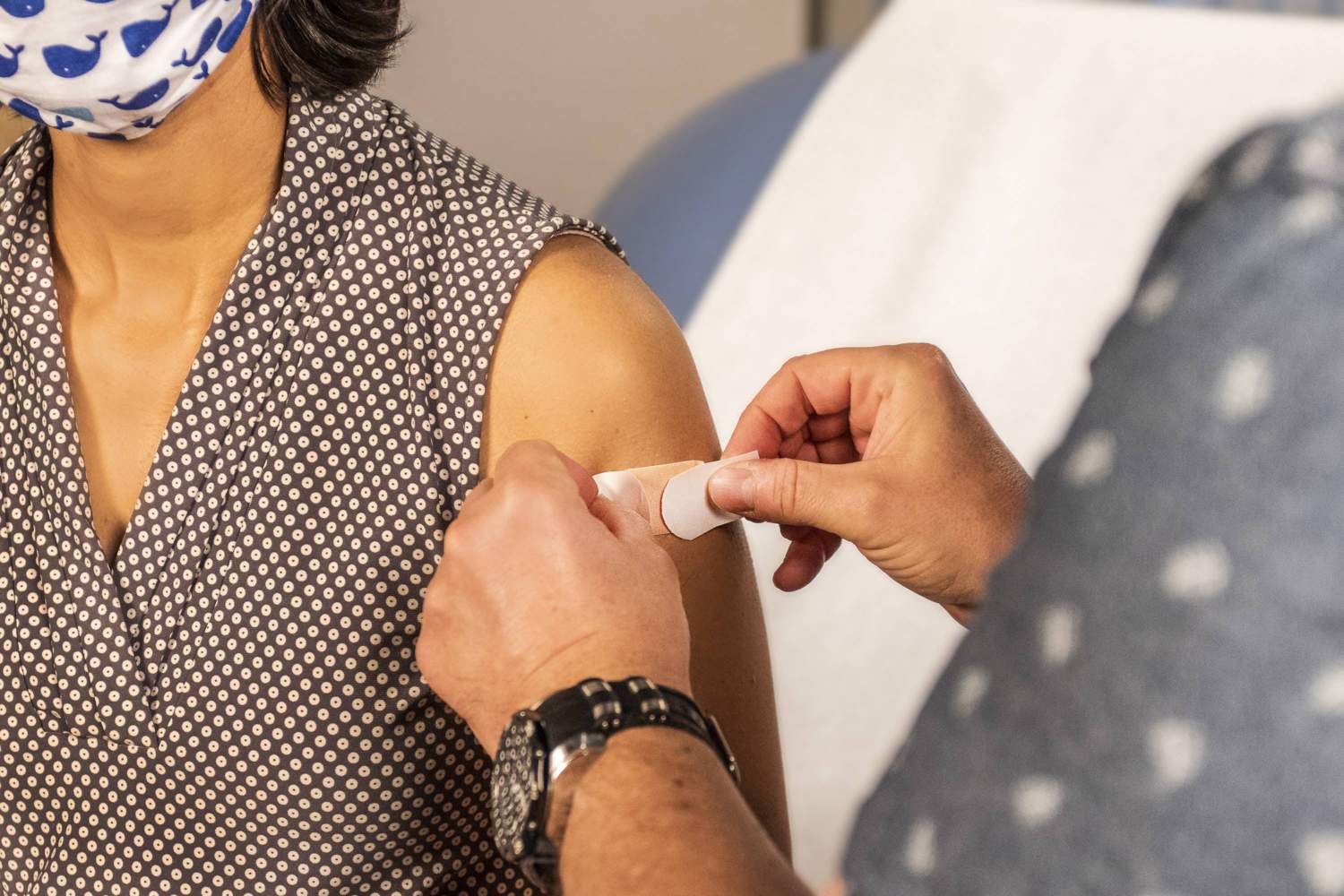 woman receiving a band-aid after getting a vaccine shot