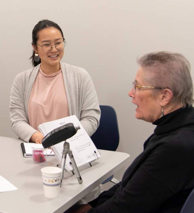 older woman working with communication disorders student